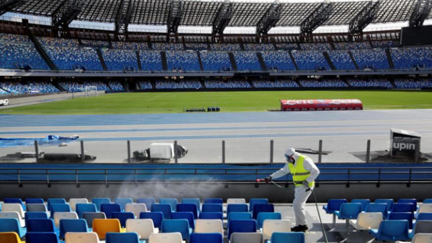 Un operario descontamina las gradas del estadio de San Paolo.