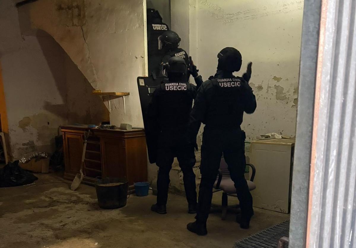 Agentes de la Guardia Civil, en el interior de una vivienda de Alberic.