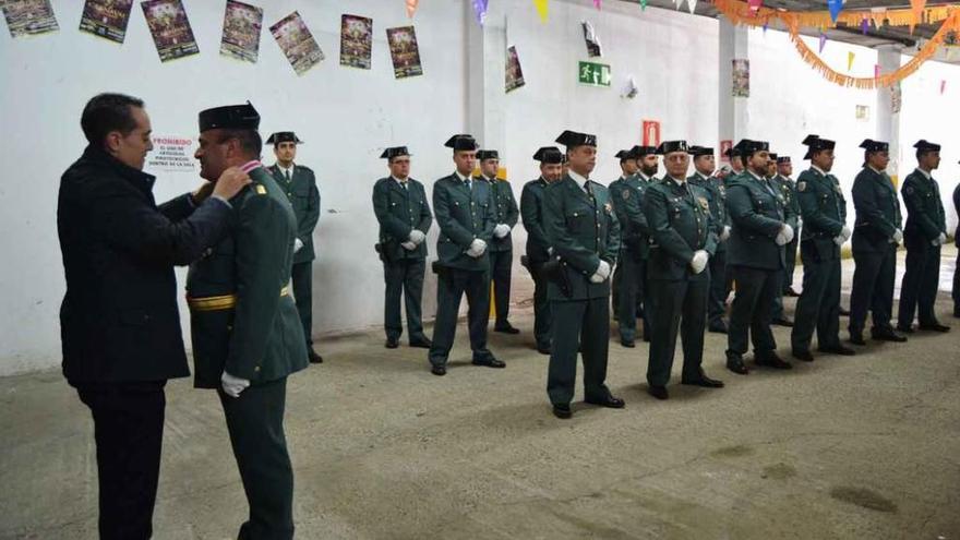 El alcalde (izqda.) impone una de las medallas de reconocimiento a un agente.