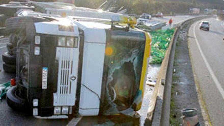 Agentes de la Guardia Civil junto al camión que transportaba productos avícolas envasados y que ha volcado hoy en la AP-9, a las afueras de Santiago de Compostela. El conductor del camión ha fallecido en el siniestro. // EFE