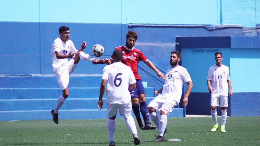 El delantero Rubén Rosquete, rodeado de jugadores del Puerto Cruz.