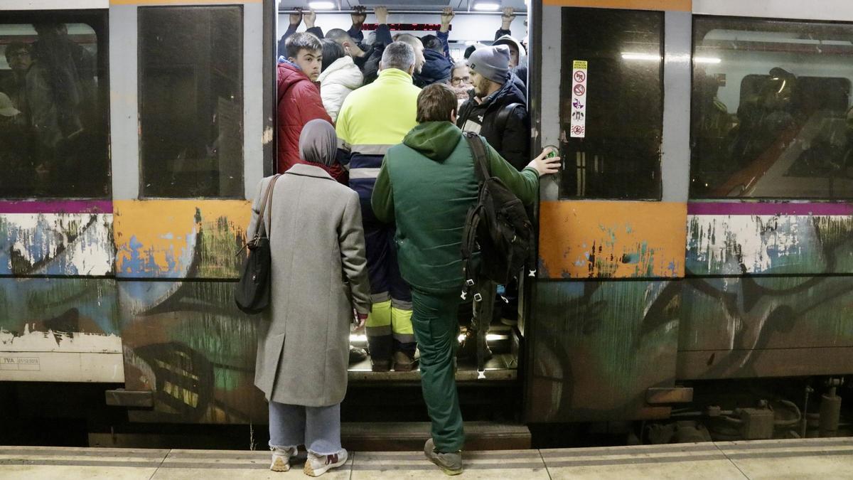 Un tren sense espai i amb passatgers sense poder entrar per la reducció de freqüències que provoca la vaga del sector.