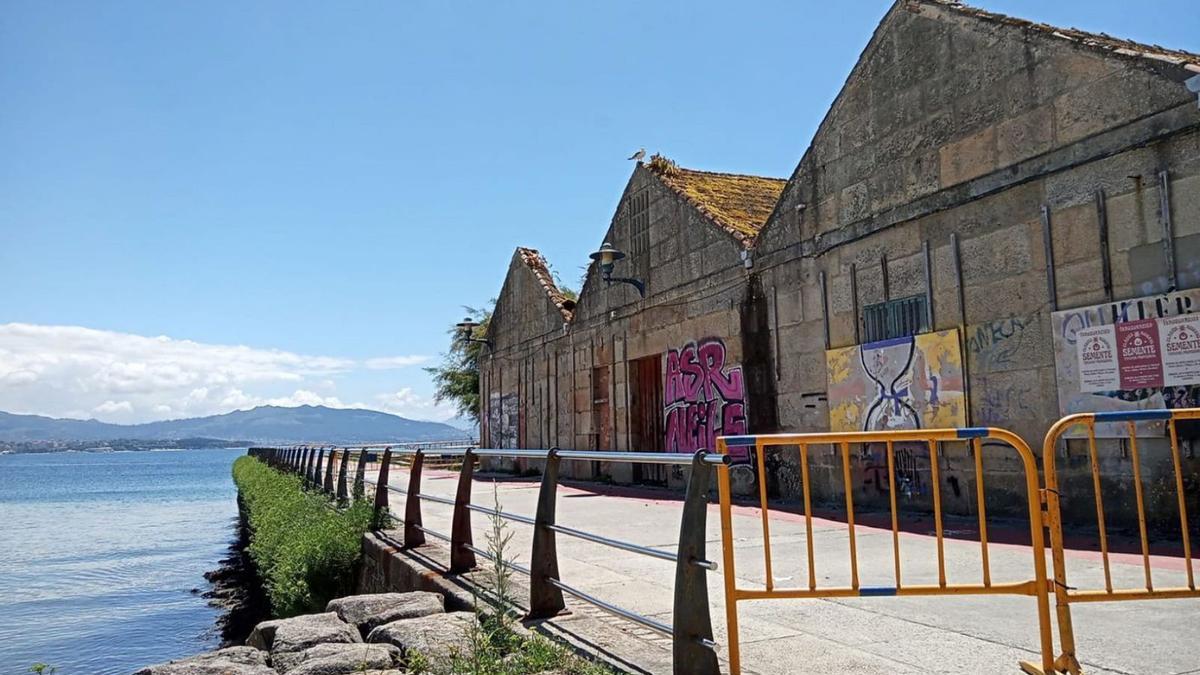 Vallado de las naves de Ojea que corta el paseo marítimo y el carril bici.   | // FDV 