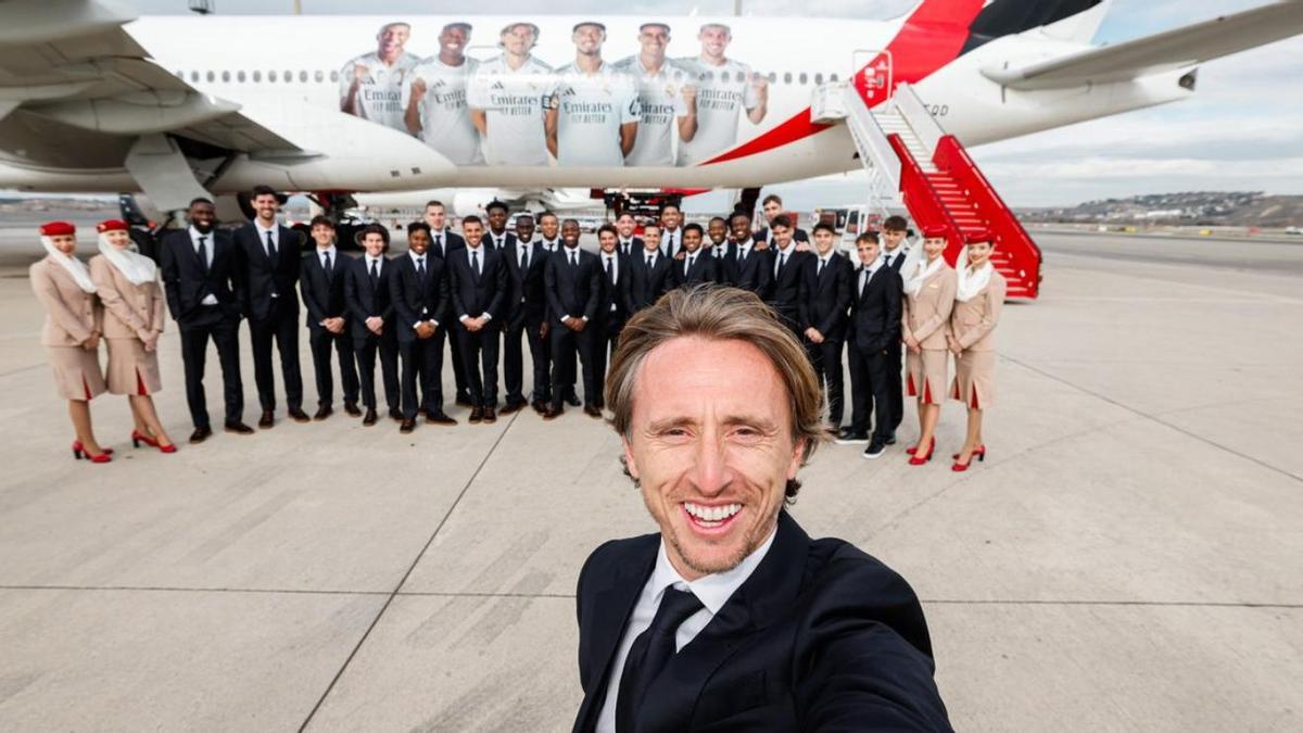 Luka Modric posa delante de sus compañeros y de un avión con la imagen de los jugadores del Real Madrid