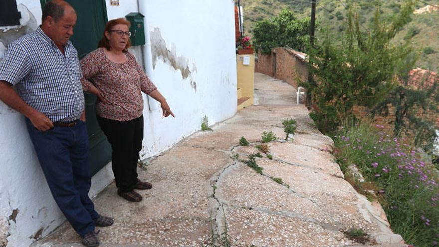 Dos vecinos contemplan con preocupación, delante de su vivienda, el avance del derrumbe de la calle municipal Escritor Maruján Cabrera.