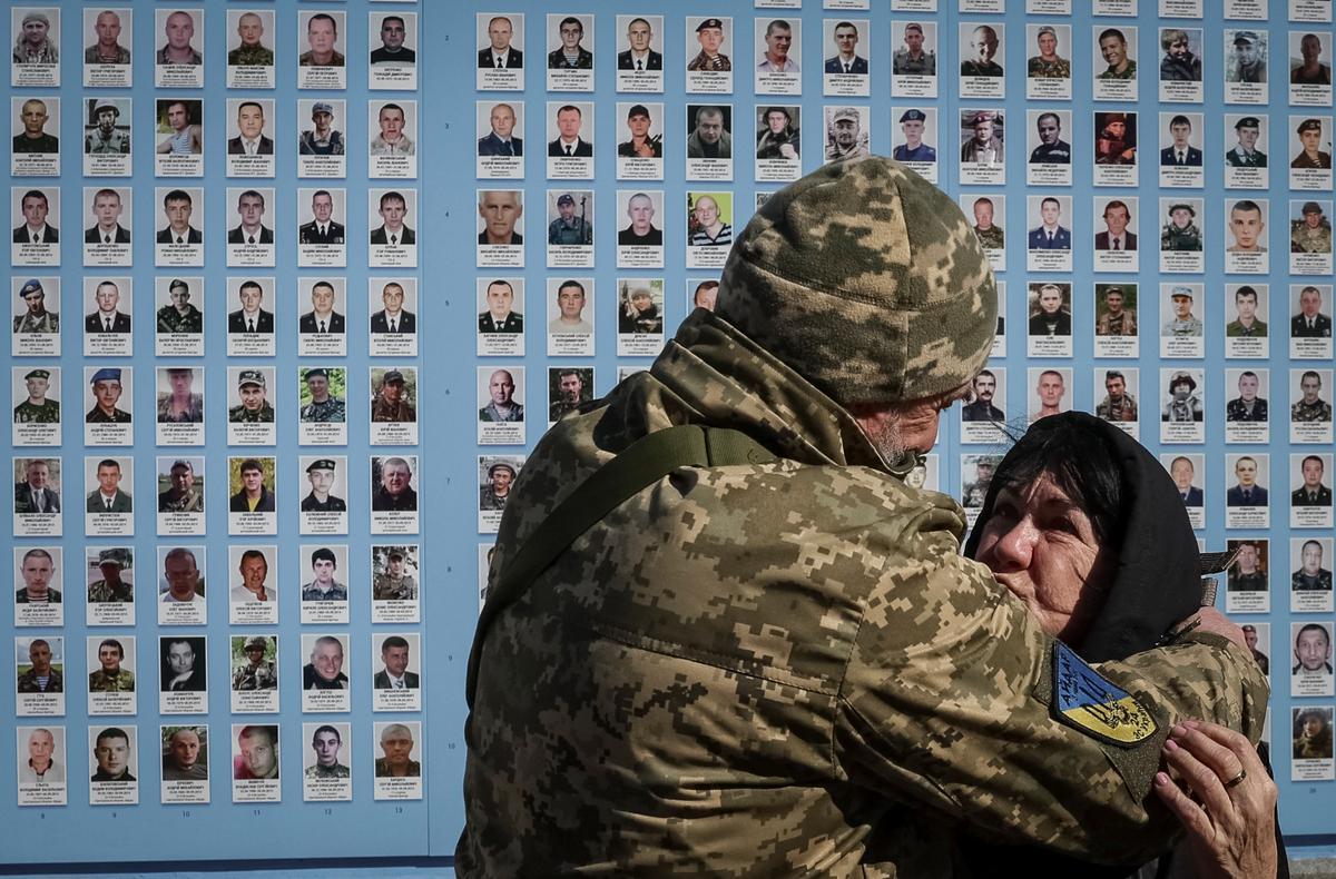 La gente visita el Muro del Recuerdo para conmemorar el Día de los Voluntarios en honor a los combatientes muertos que se unieron a las fuerzas armadas ucranianas.