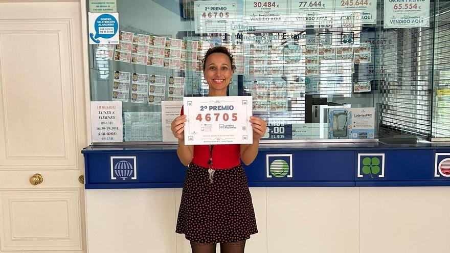 Carolina Aparicio Rodríguez, lotera de la administración La Campesina, situada en Los Zocos, en Costa Teguise (Lanzarote), este sábado con el cartel del segundo premio del Sorteo Extraordinario de Invierno de la Lotería Nacional