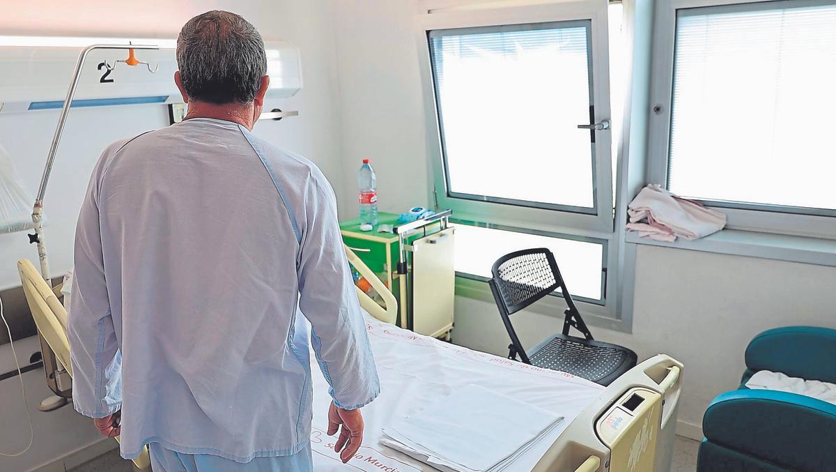 Un paciente de larga duración junto a una camilla del hospital Reina Sofía