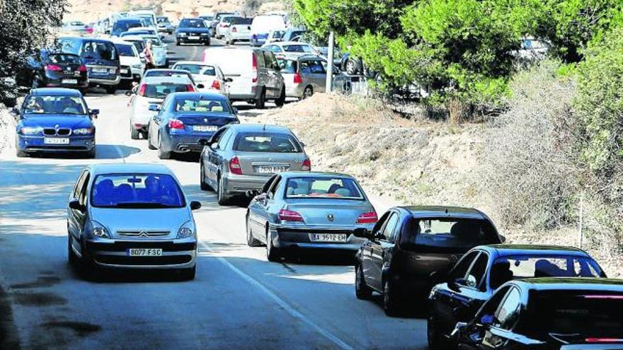 Retención de vehículos en el antiguo camino al Cementerio de Sant Jaume, ayer al mediodía.