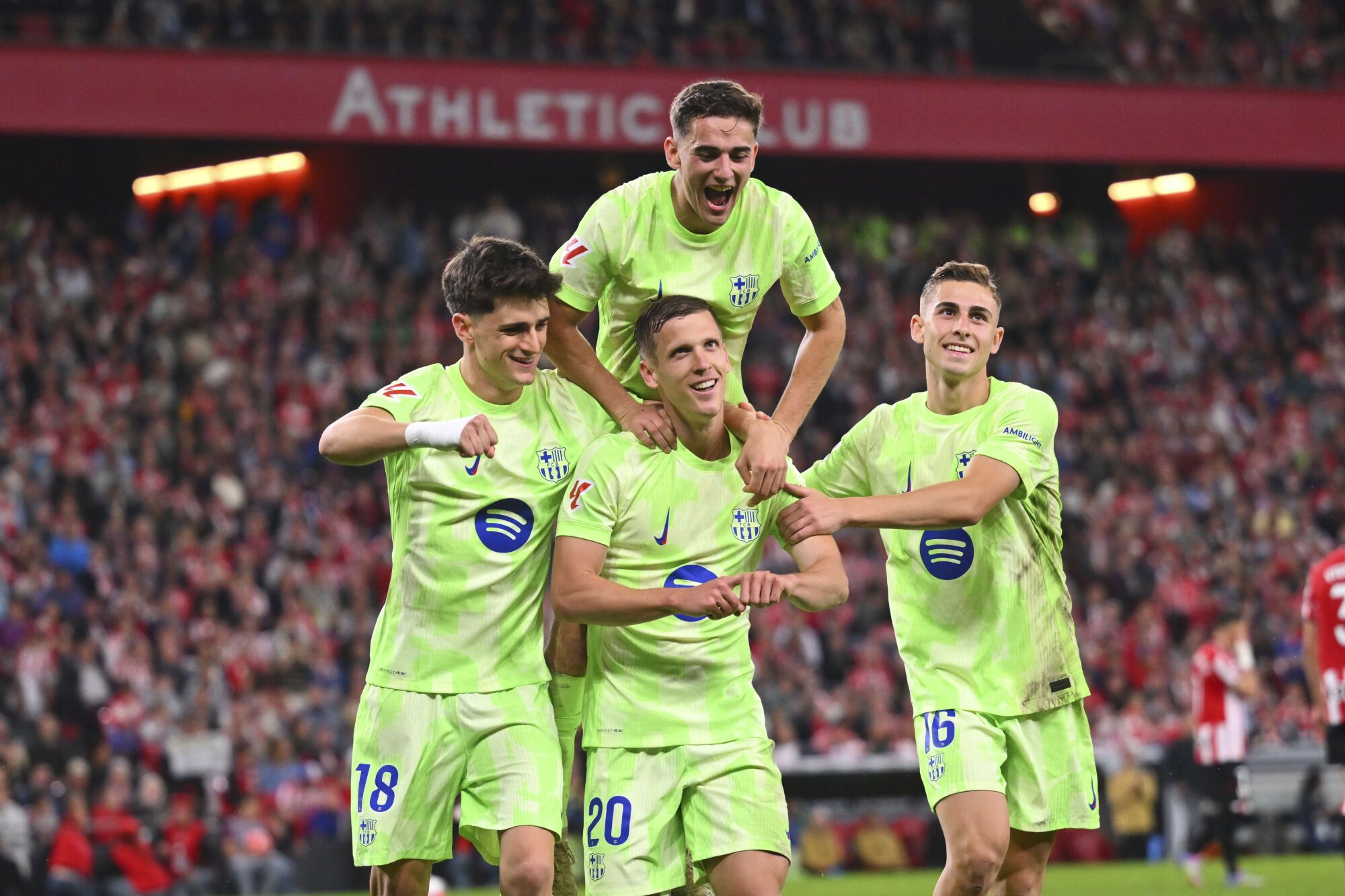 Barcelona's Dani Olmo (20) is congratulated after scoring his side's 3rd goal from the penalty spot during the Spanish La Liga soccer match between Athletic Bilbao and Barcelona at the San Mames stadium in Bilbao, Spain, Sunday, May 25, 2025. (AP Photo/Miguel Oses)