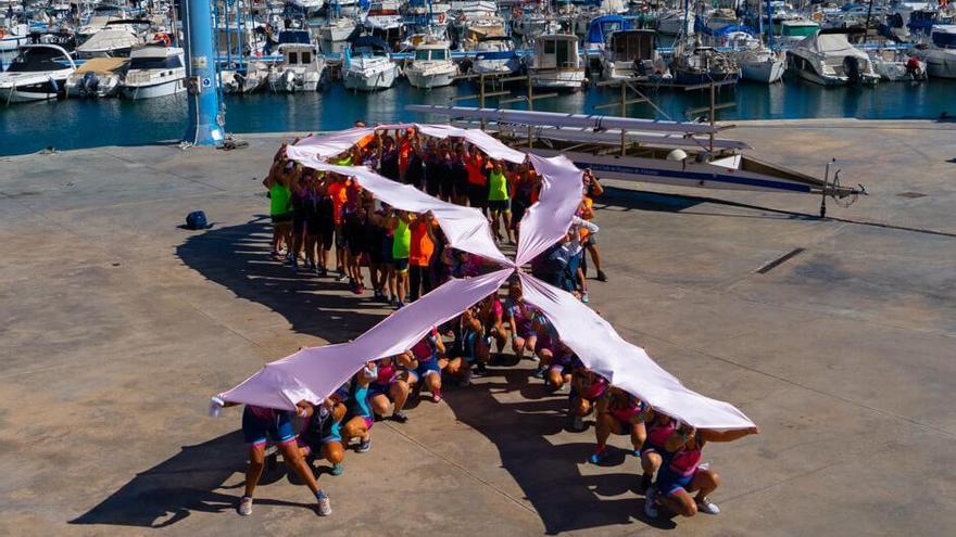 Los participantes con un lazo rosa contra el cáncer de mama