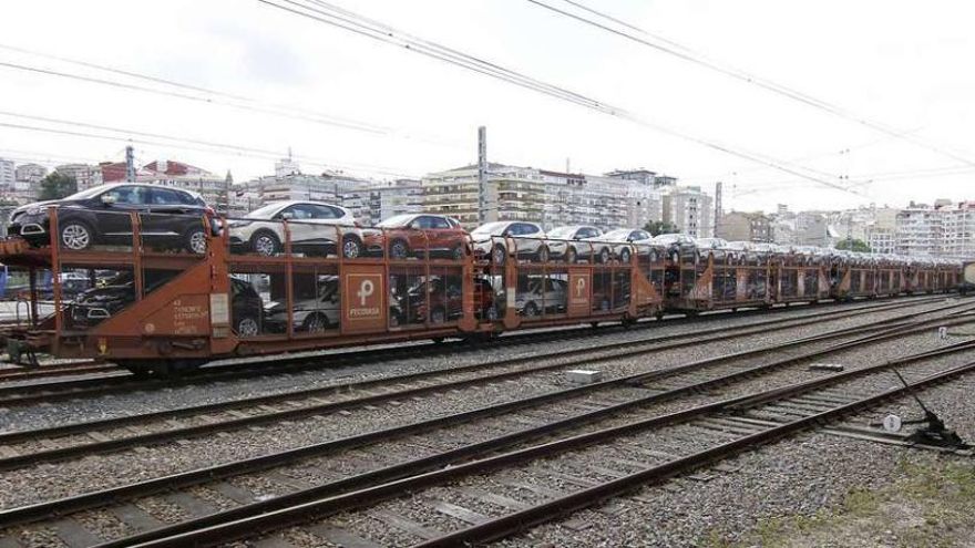 Una vieja demanda de los operadores que mueven vehículos | En la imagen, tomada en 2013 en Areal, aparece un convoy lleno de vehículos. Para completar esta secuencia faltaría la toma donde aparecería una caravana de camiones cargando todos esos coches para trasladarlos a continuación hasta Bouzas. Este es un ejemplo de la enrevesada operativa que abordan empresas que se aventuran a traer en tren vehículos producidos fuera de Vigo para su exportación a través del puerto vigués. Por eso demandan desde hace años la conexión ferroviaria de Bouzas. "Cada vez hay más operadoras que nos piden ese tren", asegura Veiga. A uno que podría interesarle, y mucho, es al que se propone embarcar cada año en la autopista del mar 30.000 vehículos de Renault producidos en Valladolid y Palencia. Ya lo está haciendo, pero con bastantes complicaciones. En este caso, los coches llegan a Porriño en tren y desde aquí en tráiler hasta Bouzas. Una logística "surrealista", en palabras del presidente portuario.