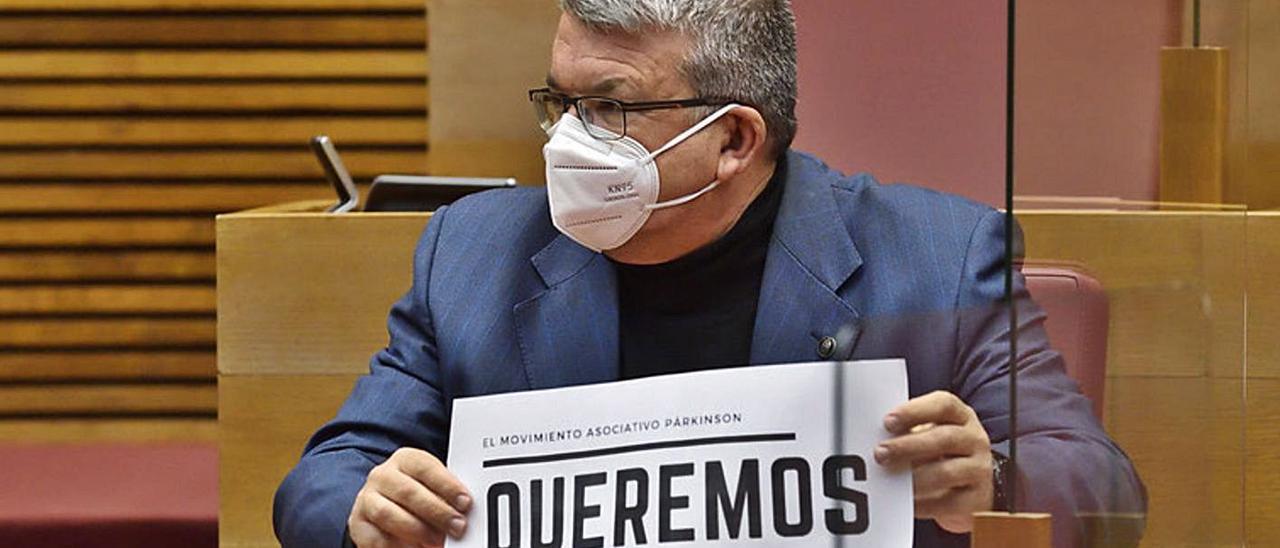 El diputado de Ciudadanos Fernando Llopis exhibe un cartel en apoyo a enfermos de párkinson. | I. C.