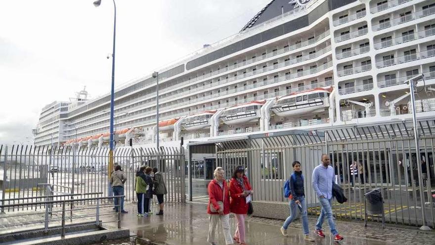 Cruceristas junto a un transatlántico en el puerto de A Coruña.