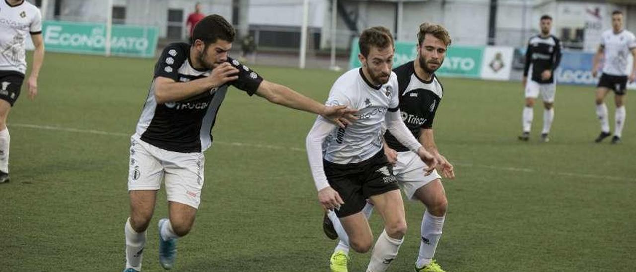 El caudalista Robert conduce el balón ante los avilesinos Imanol y Félix.