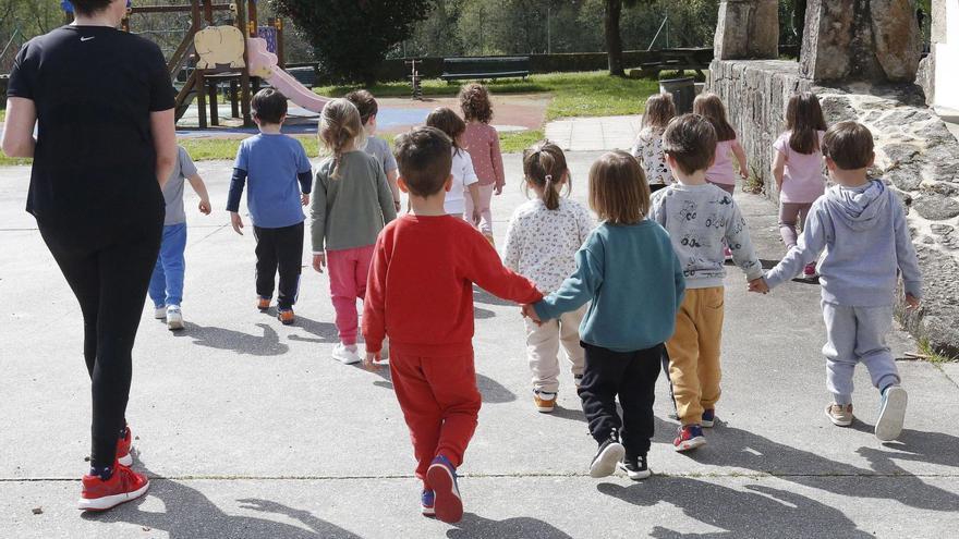 Rosa Pose, de la escuela infantil unitaria de O Rial, en Laraño, junto a parte de sus alumnos en las instalaciones del centro