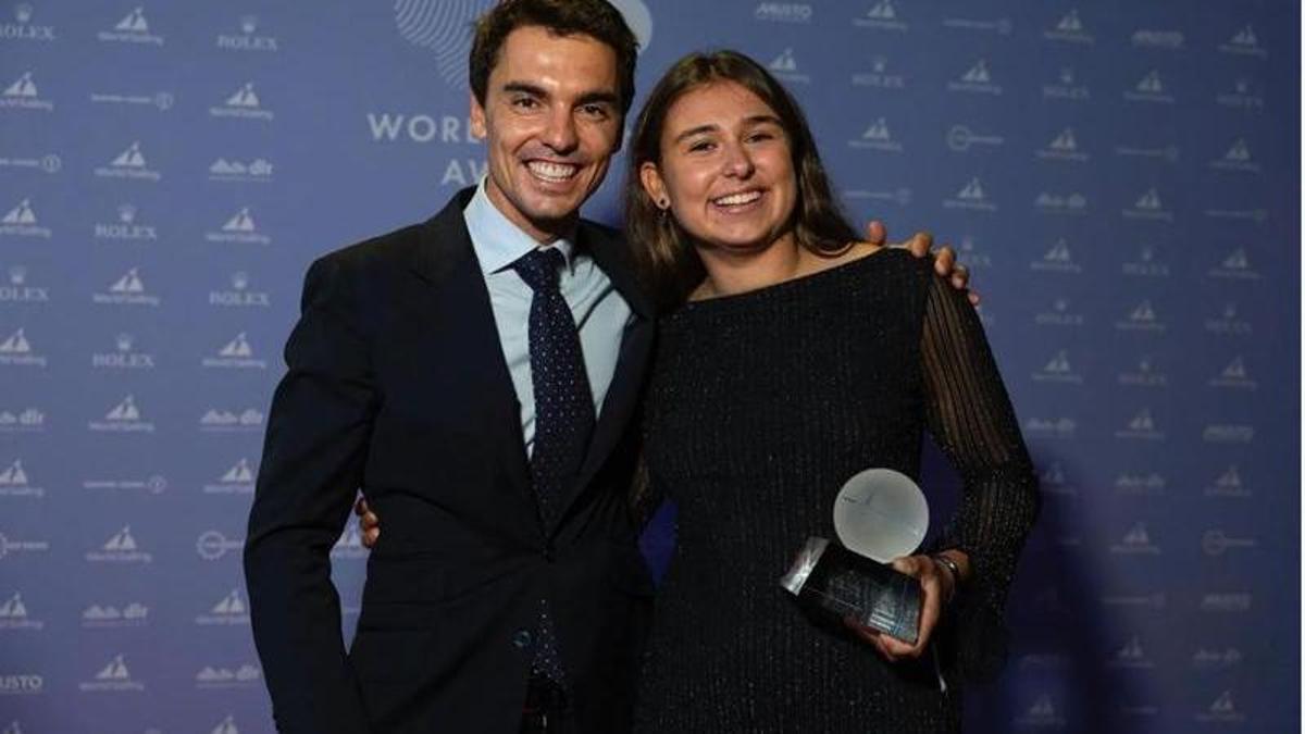 Marta Cardona, junto a Jordi Xammar, posa con el premio que la acredita como mejor regatista joven del mundo.