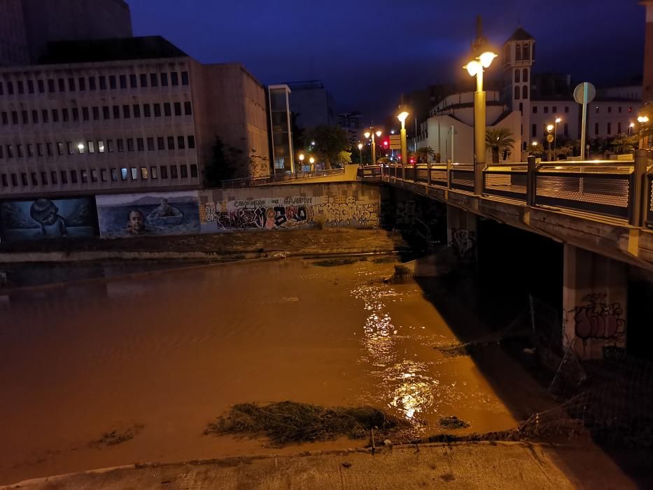 Inusual imagen, en Málaga capital, del cauce del Guadalmedina cubierto por el agua.