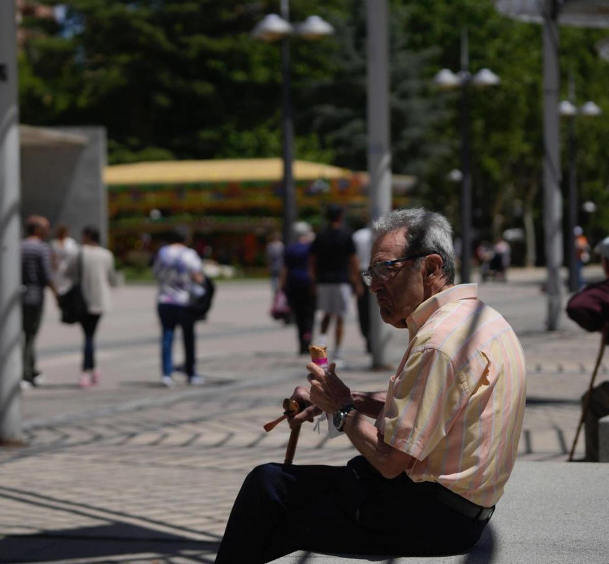 Un hombre combate el calor comiendo un helado. | Jose Luis Fernández