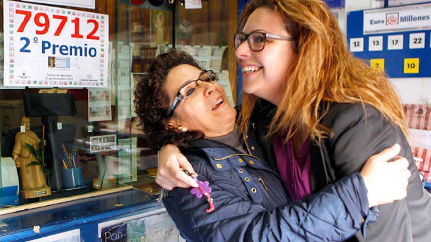 La propietaria de la administración de lotería de Granadilla de Abona que vendió el segundo premio se abraza con una amiga.