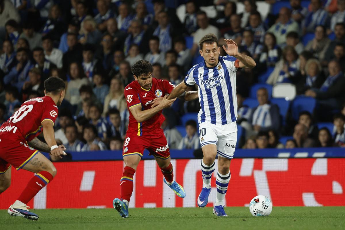 El centrocampista uruguayo del Getafe Mauro Arambarri pelea un balón con el delantero de la Real Sociedad Mikel Oyarzabal durante el partido de la jornada 33 de LaLiga entre la Real Sociedad y Getafe CF, este miércoles en el estadio de Anoeta en San Sebastián