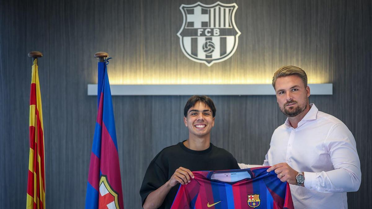 Jony Hernández sostiene una camiseta del Barça junto a Kevin Pérez, de la empresa re representación Élite FGC Agency, en las oficinas del FC Barcelona.
