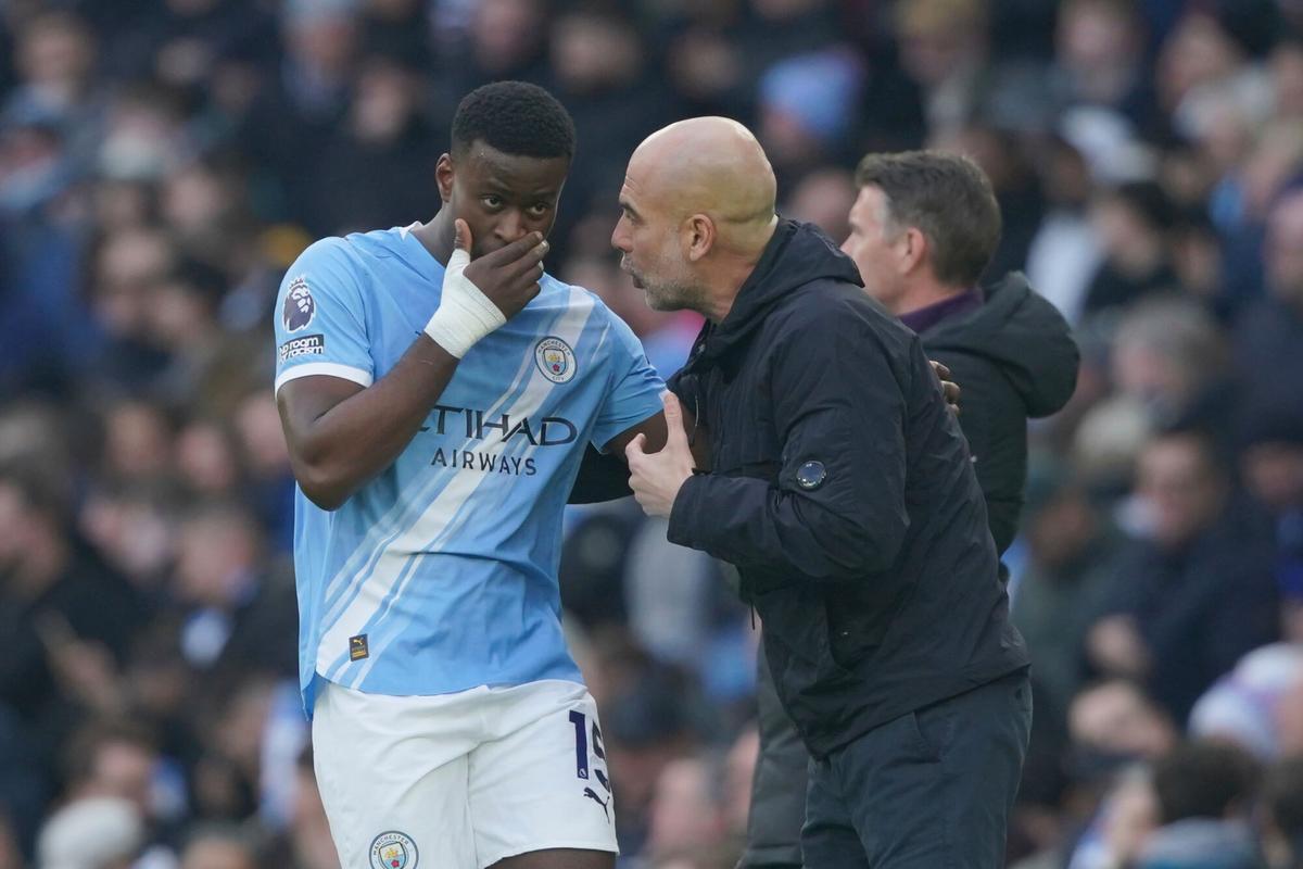 Marc Guéhi charla con Pep Guardiola