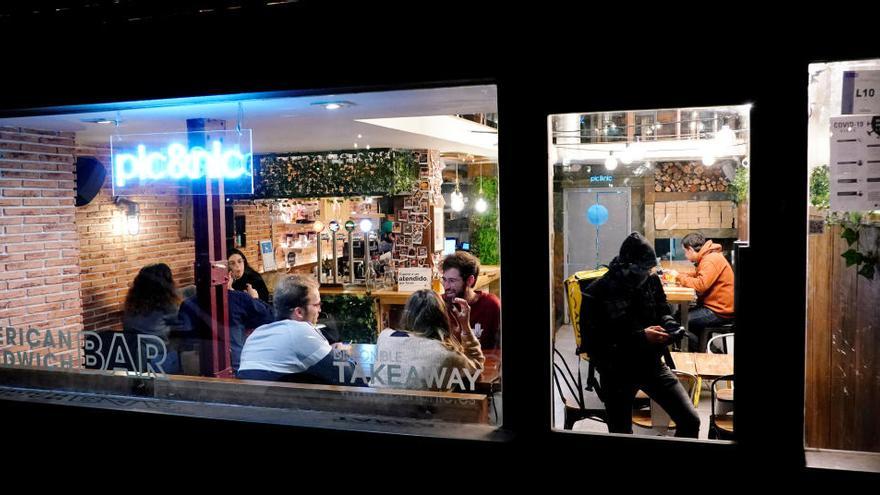 Personas cenan en el interior de un bar en Madrid