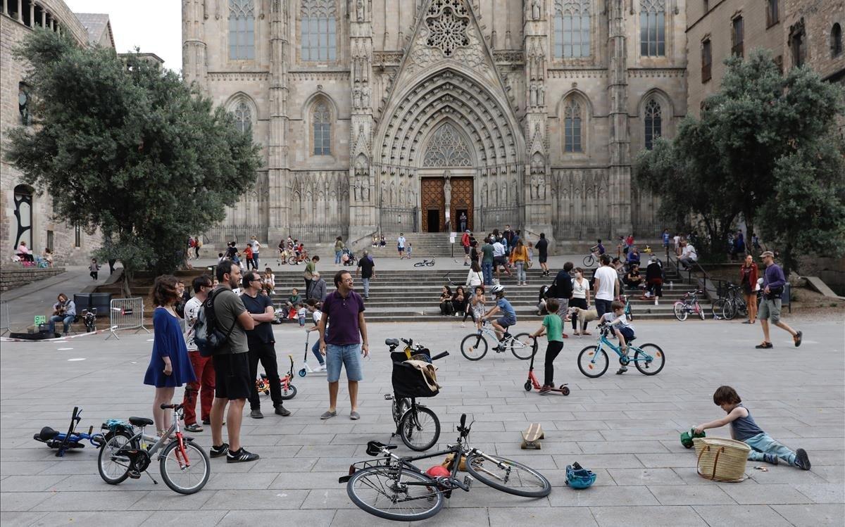 Vecinos con bicicletas frente a la catedral de Barcelona, sin turistas.