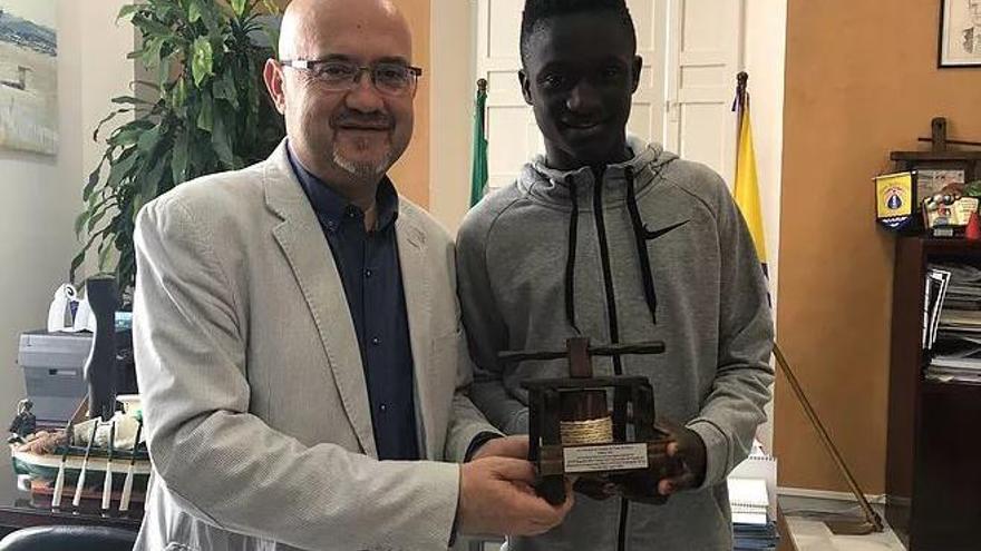 Bakary, recibiendo un reconocimiento con el teniente alcalde de Torre del Mar.