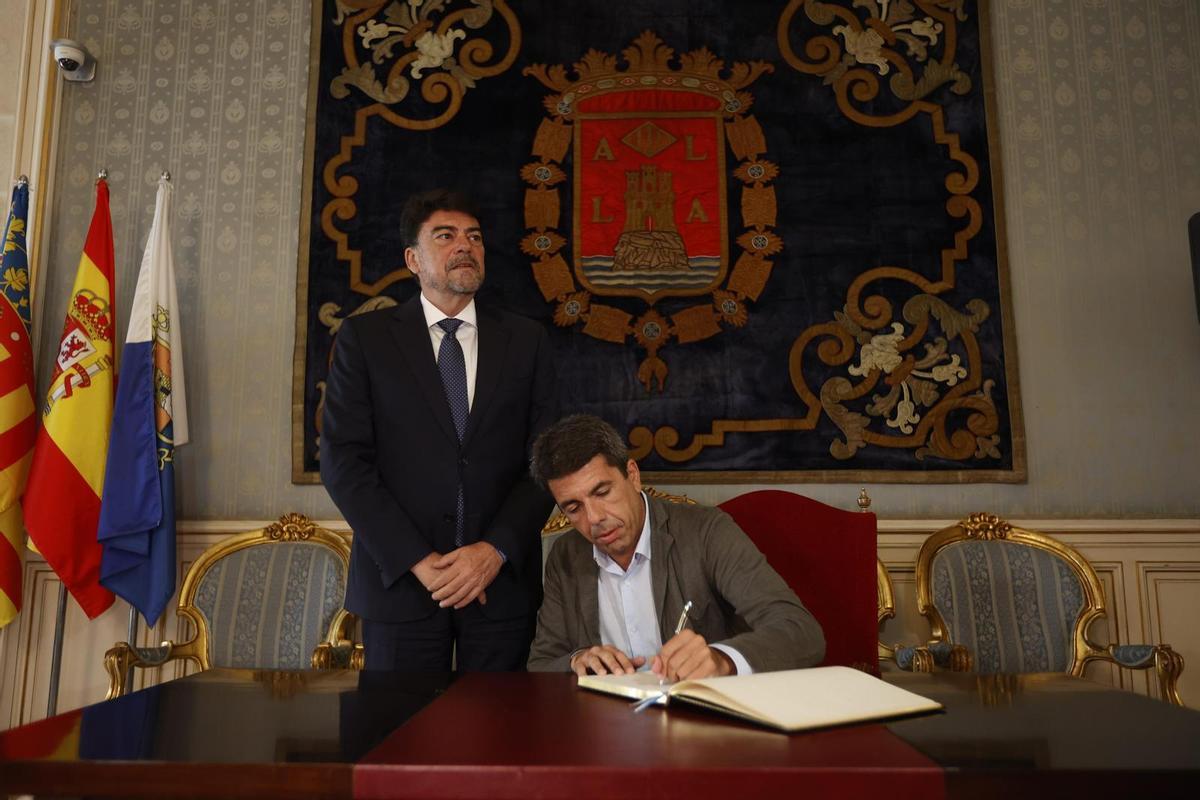 Mazón firma en el libro de honor del Ayuntamiento de Alicante, en su visita de este lunes