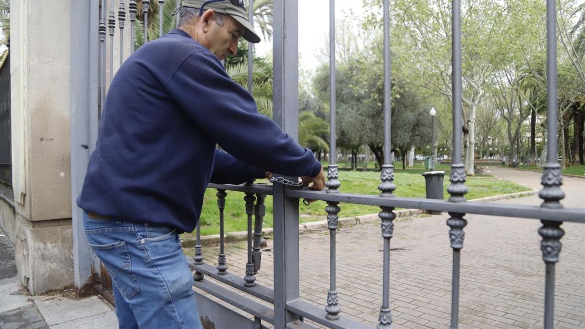 Un operario de Parques y Jardines cierra el jardín de Colón ante la previsión de lluvias y viento, este viernes.