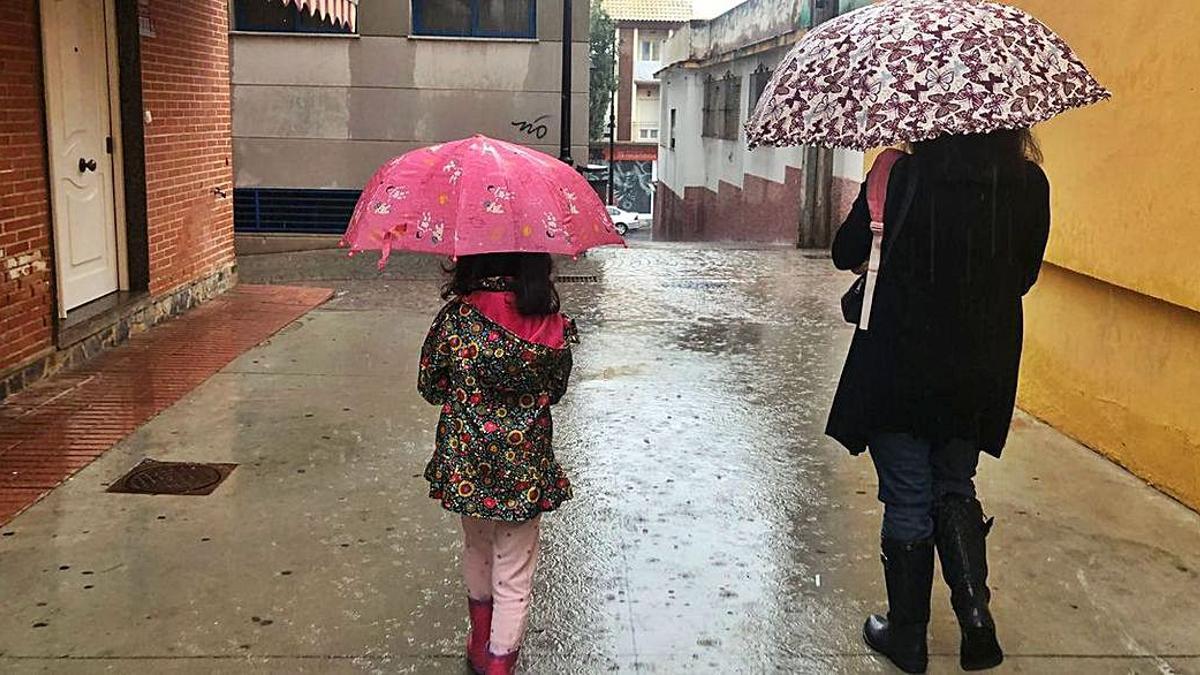 Una mujer y una niña se protegen de la lluvia el pasado domingo.