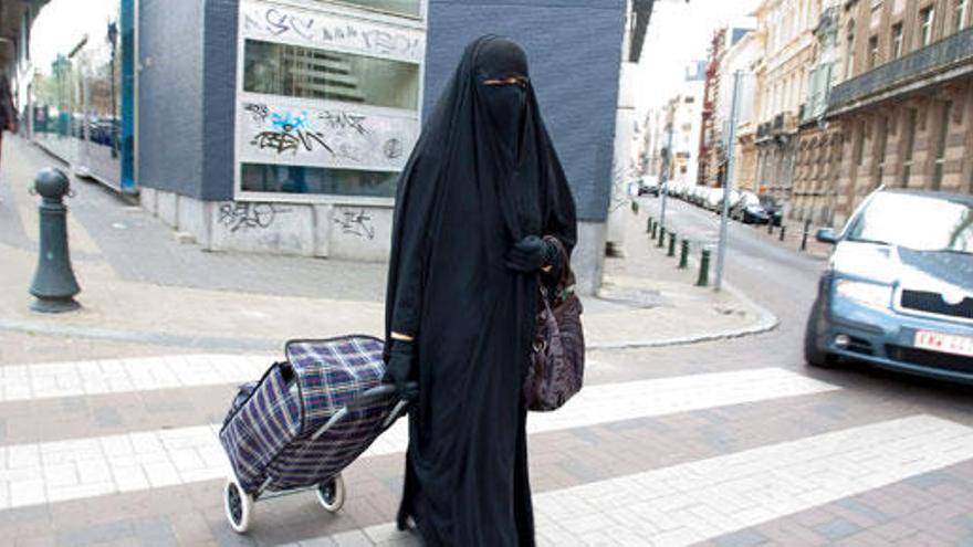 Una mujer con burka acude a hacer la compra.