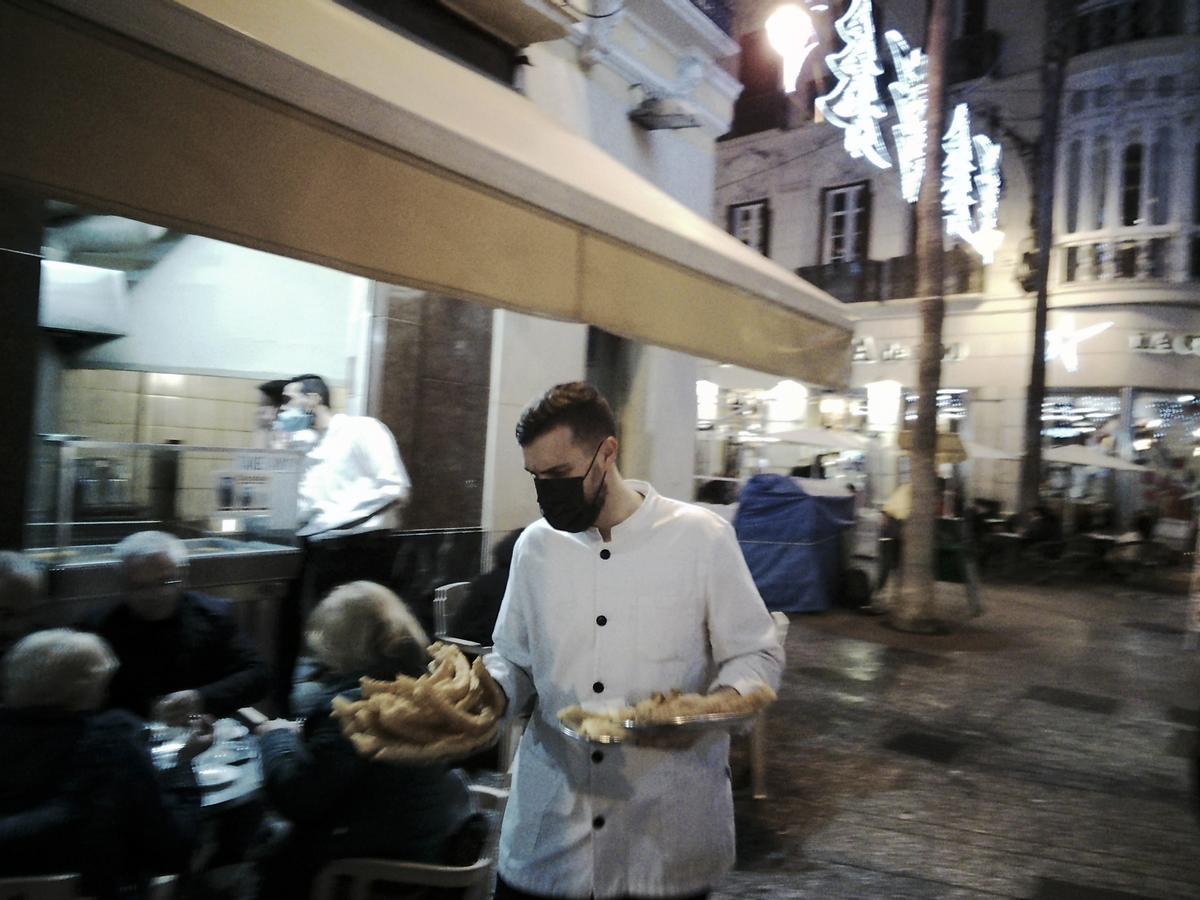 Un camarero sirve churros en el Casa Aranda.