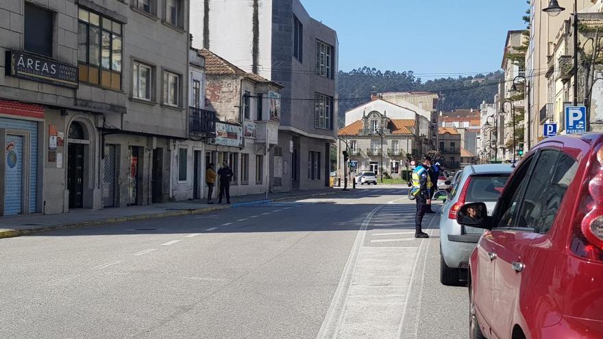 Un agente de la Policía Local ante la cola de coches de esta mañana.