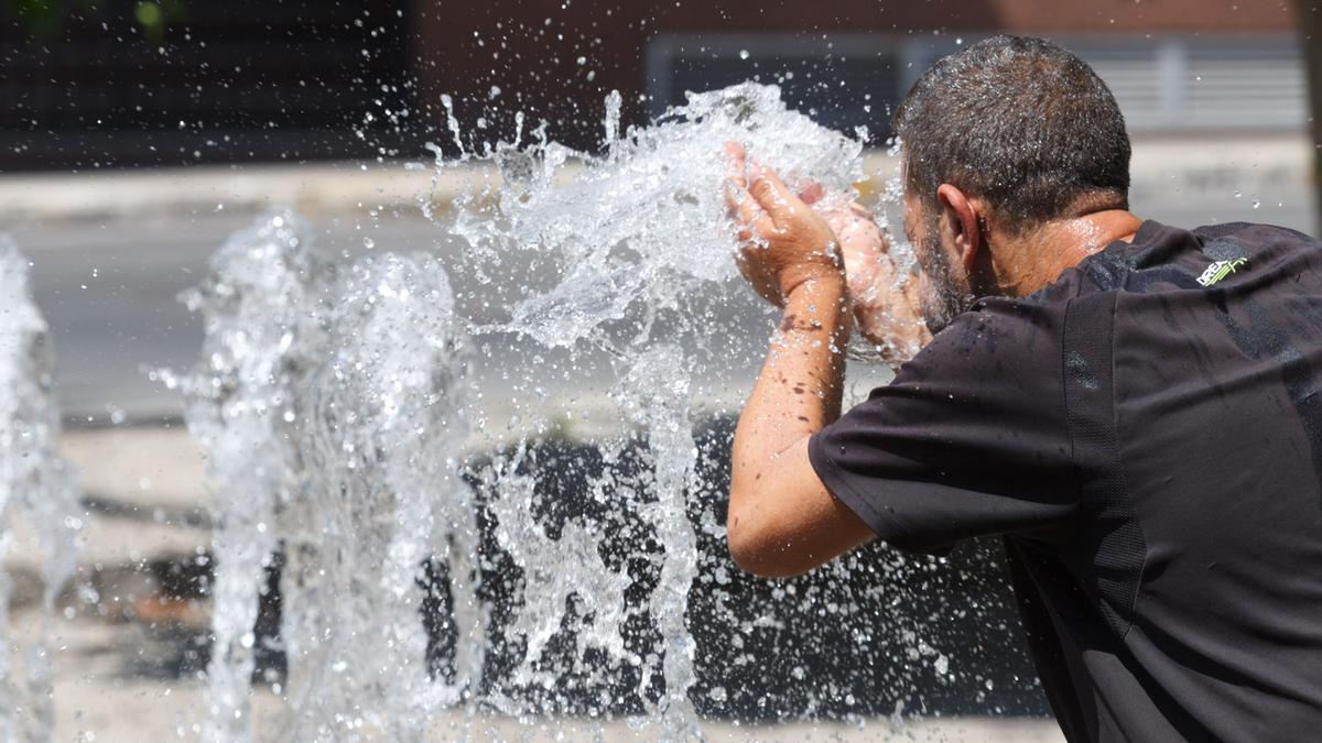 Un hombre se refresca en una fuente de Alicante este lunes