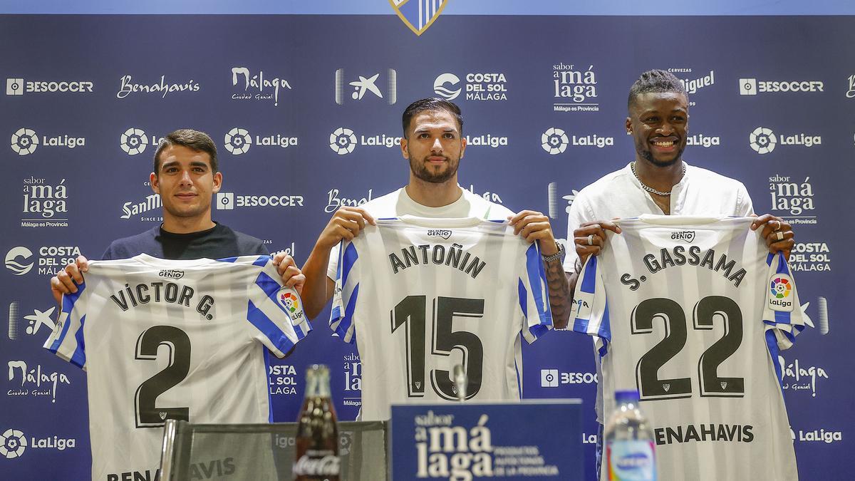 Víctor Gómez, Antoñín y Gassama, con sus camisetas del Málaga CF.