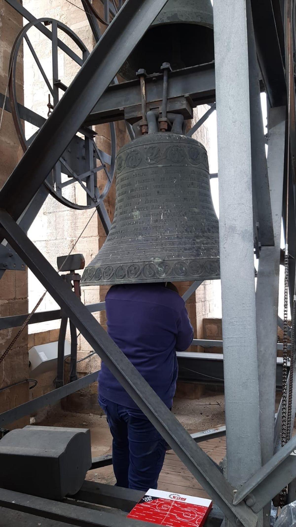 Un operari treballant literalment dins d'una campana de la Seu