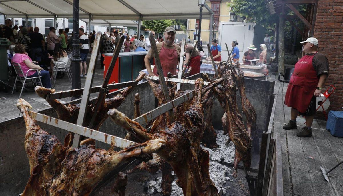 Los corderos, en pleno asado en la plaza de Trubia. | FERNANDO RODRÍGUEZ