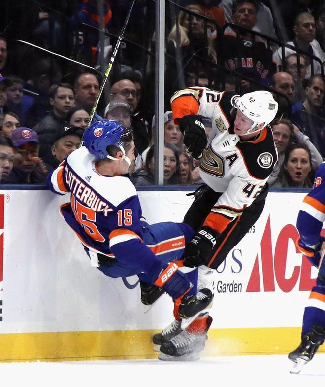 Josh Manson # 42 de los Anaheim Ducks llega a Cal Clutterbuck # 15 de los New York Islanders durante el primer período en NYCB Live en el Nassau Veterans Memorial Coliseum.