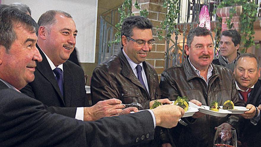 El alcalde redondelano Javier Bas, y el presidente de la Asociación de Empresarios, José Antonio Gómez –a su izquierda–, degustan unas tapas de choco, ayer, en el restaurante O Canastro.  // David Vázquez