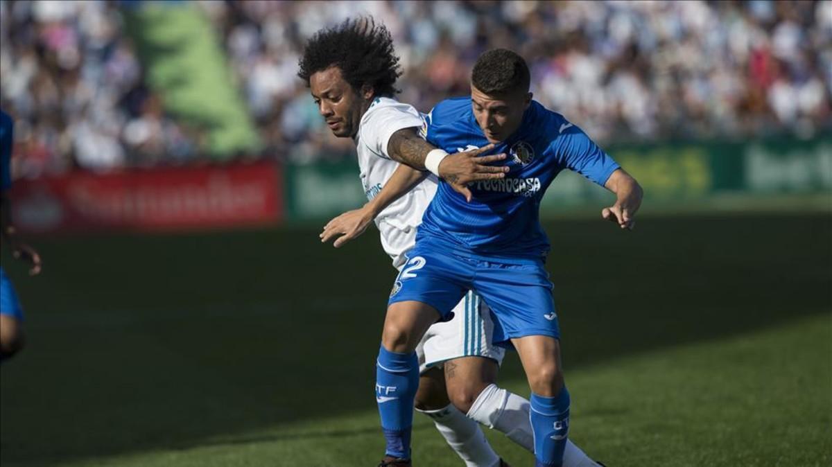 Marcelo pelea un balón con el getafense Portillo