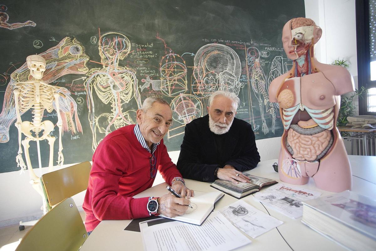 Joan San i Pep Admetlla davant de dibuixos d'anatomia en una pissarra de l'escola Eiximenis de Girona.