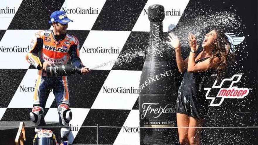 Pedrosa, tercero en la carrera de ayer, rocía de champán a una azafata de la prueba.