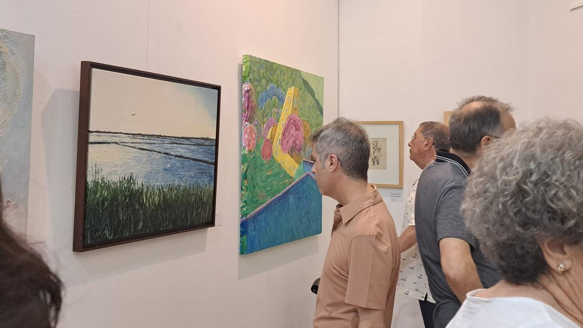 Asistentes a la inauguración observan algunas de las obras.
