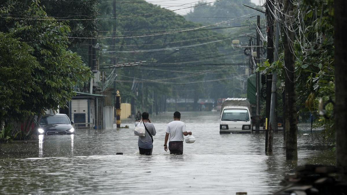 Dos personas caminan en una calle inundada tras una tormenta extrema en Bago, en Myanmar.