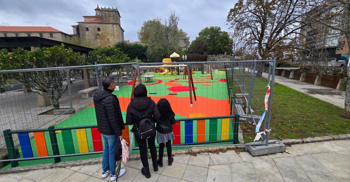 Una familia observando, ayer, el remodelado parque infantil de A Xunqueira. | M. Méndez