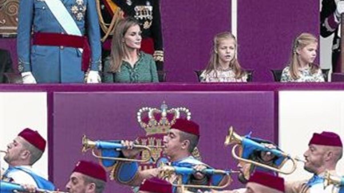 Los Reyes, junto a sus hijas, presiden el desfile militar del 12-O, ayer.