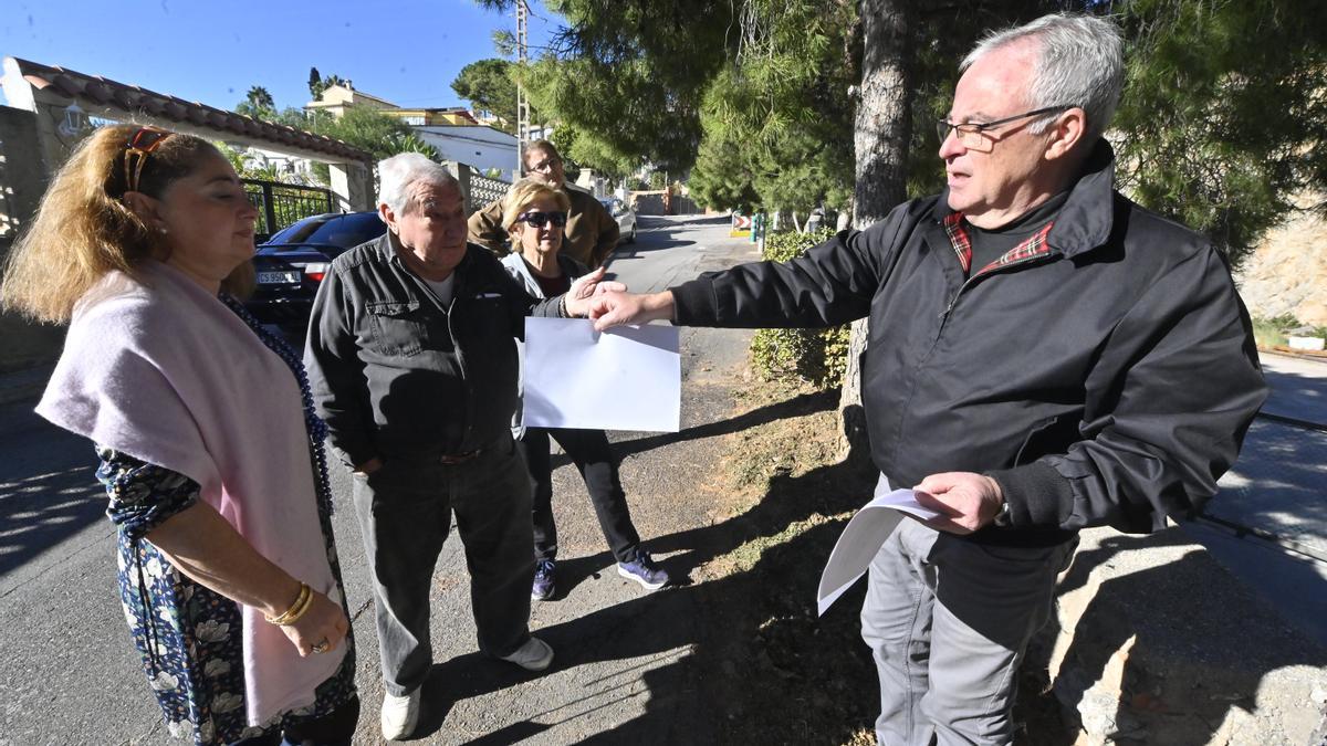 Un representante de la sociedad civil que gestiona el Pozo Peñarocha entrega un «comunicado urgente» a varios vecinos de la urbanización de Penyeta Roja de Castelló.